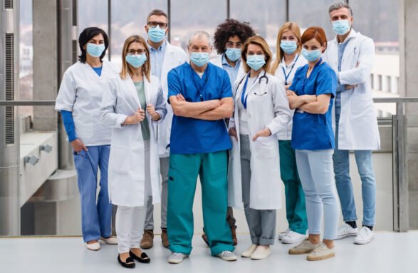 A group of doctors with face masks looking at camera, corona virus concept.
