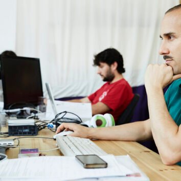 Two men focused on their work in a home office setting.